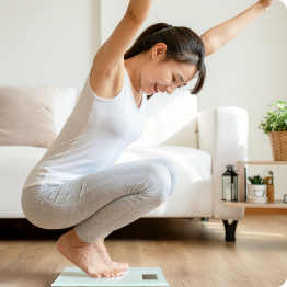 体重計に乗って喜んでいる女性